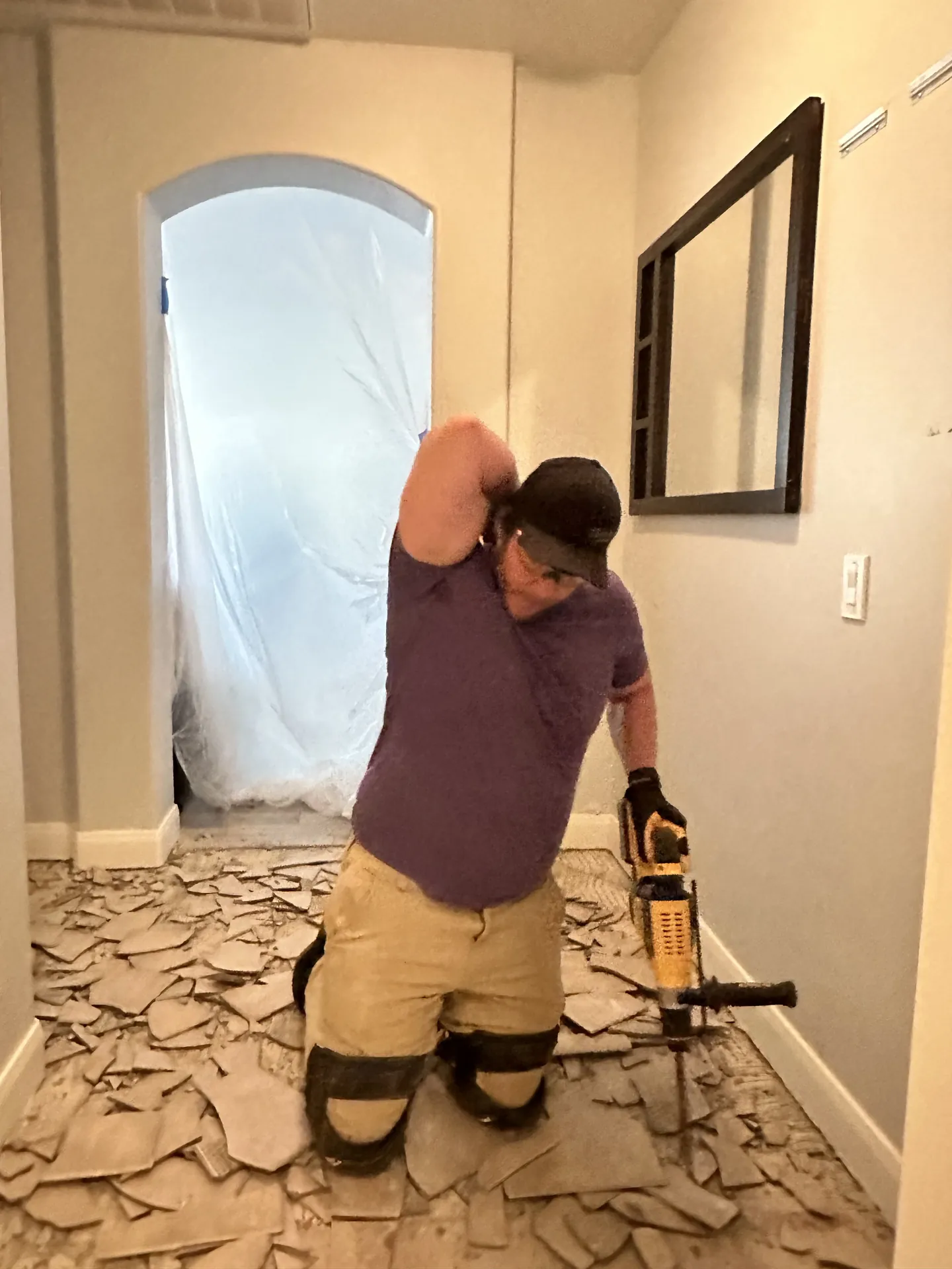 Viking Solutions crew member using a rotary hammer to break out old tile during demolition in a St. George home