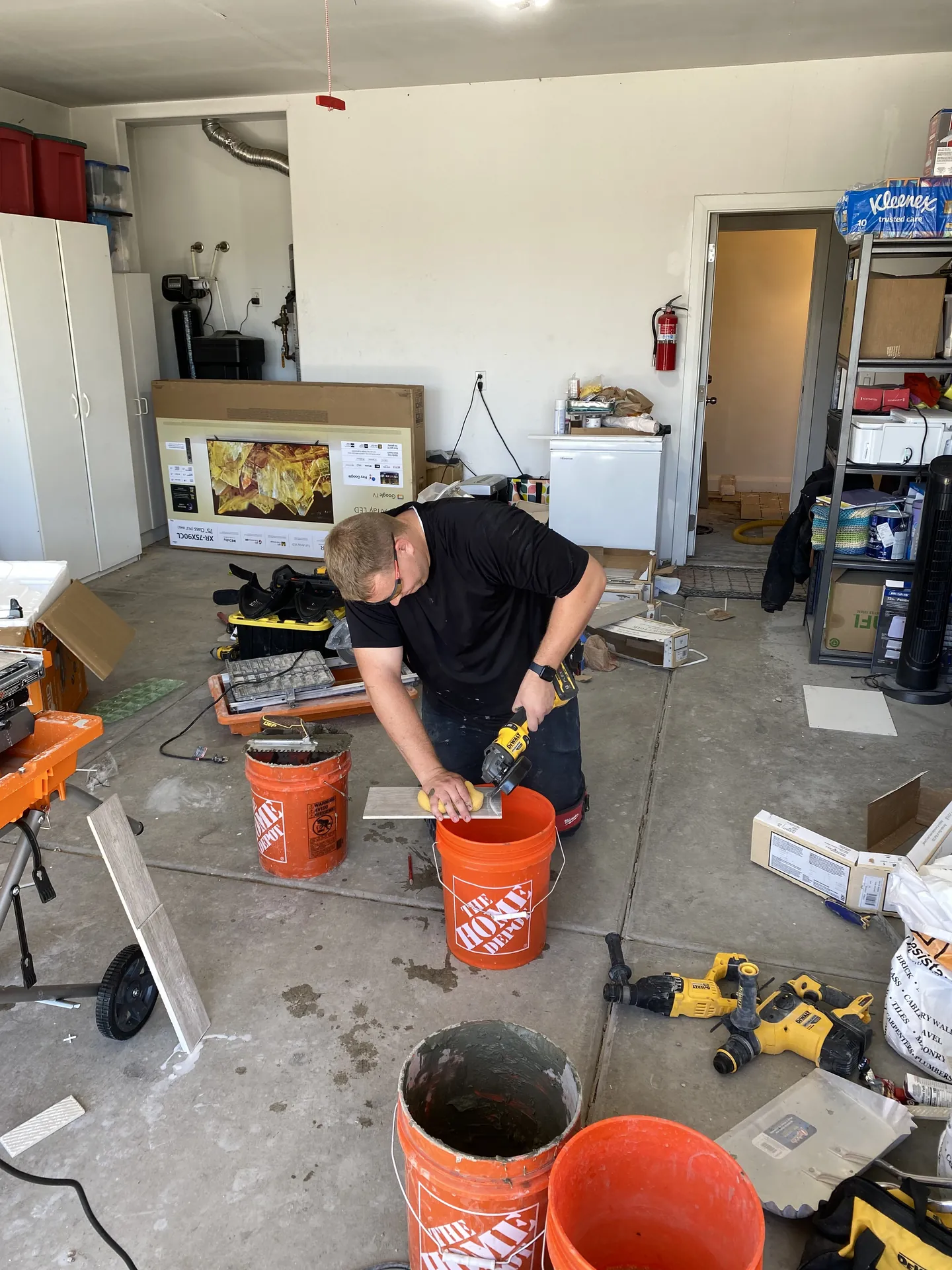Tile cutting and prep station set up in the garage with a wet saw and stacked plank tile