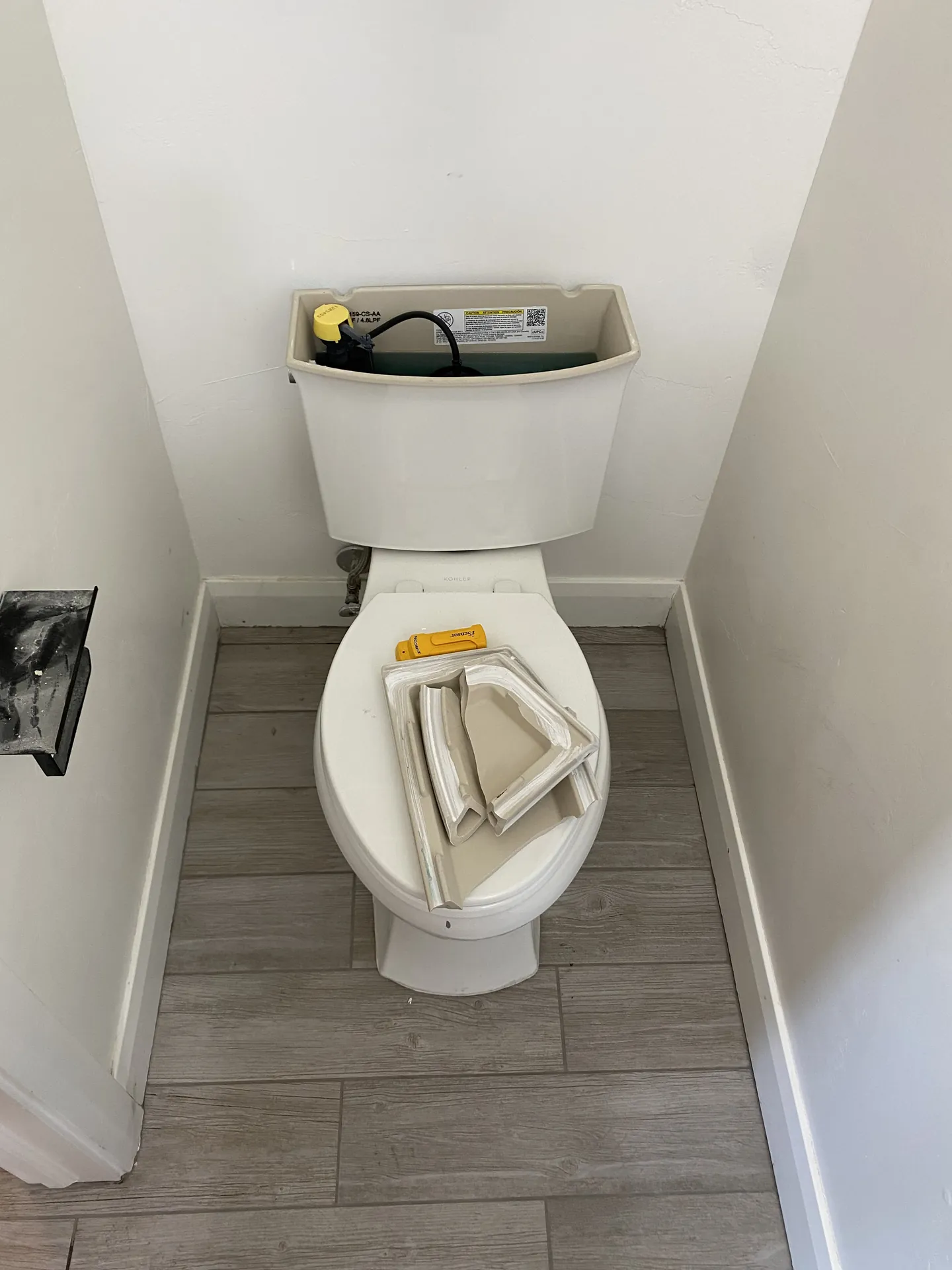New plank tile cut and fit tightly around a reset toilet base with clean grout lines