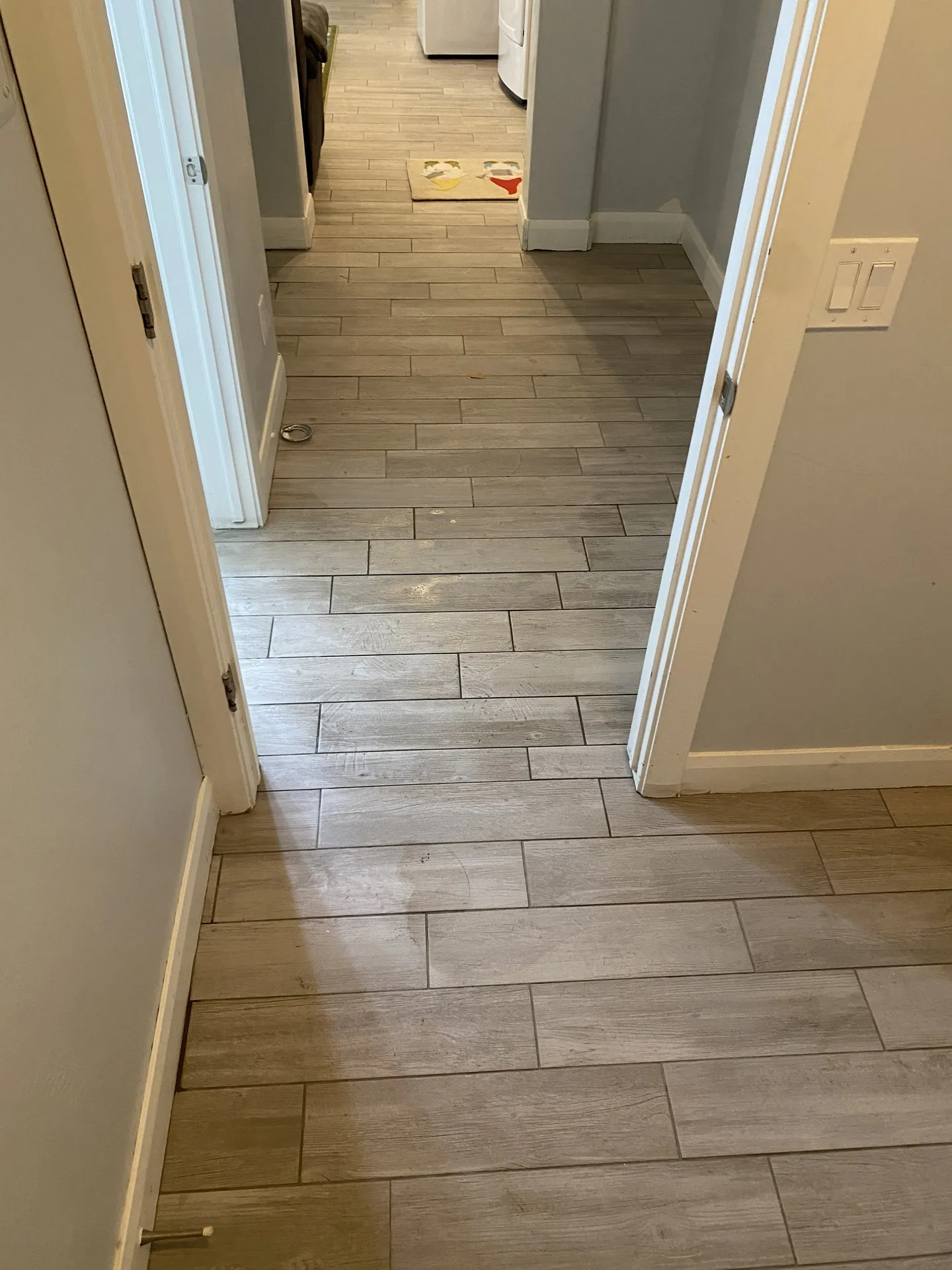 Finished wood-look plank tile running the length of a hallway and into the laundry room in a St. George, Utah home
