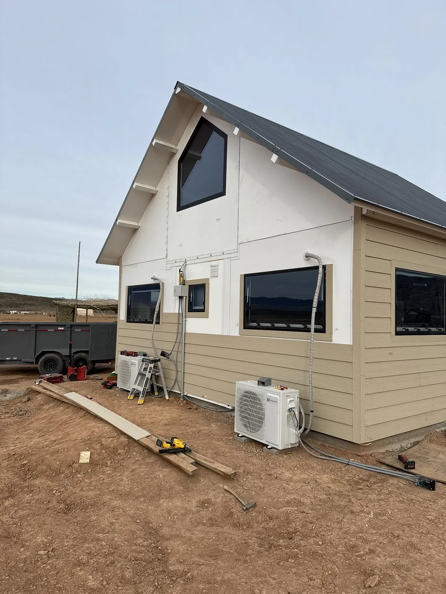 Boxabl siding installation in progress under overcast winter conditions with tools staged on site